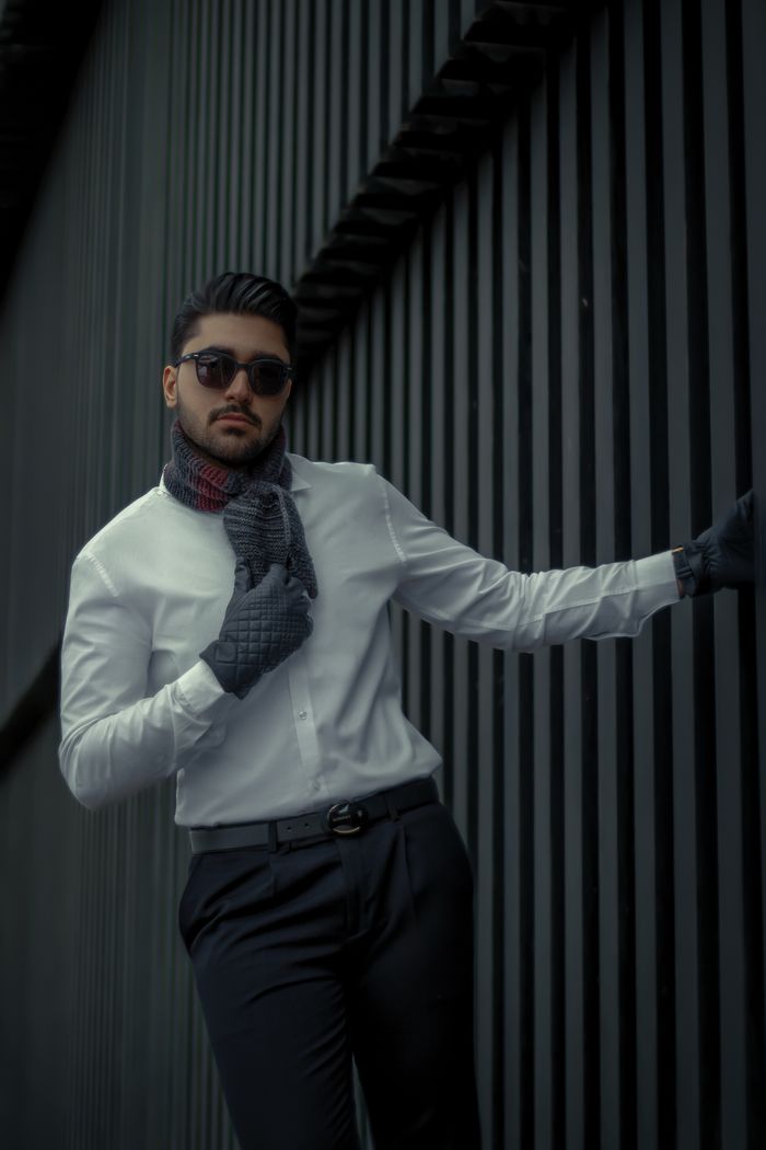 Crafting Captivating Headlines: Your awesome post title goes here Stylish man in sunglasses and scarf posing against striped wall. Ideal for fashion editorials.