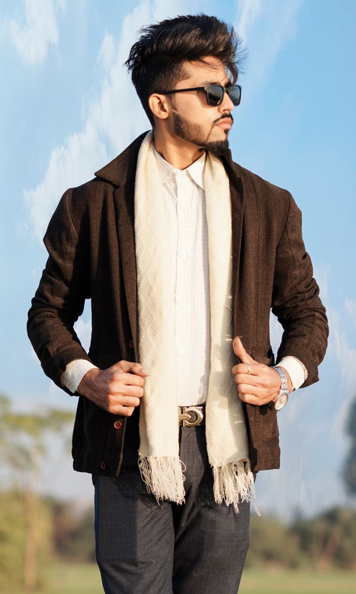 delivery-policy Fashionable adult male in sunglasses and scarf posing confidently outdoors.